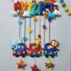 bright colorful kids name hanging with rainbow macrame and felt stitching with cars having animals
