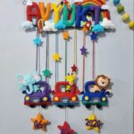 bright colorful kids name hanging with rainbow macrame and felt stitching with cars having animals