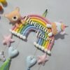 handcrafted macrame rainbow in pastel colors with kids name and cute felt unicorn and felt teddy