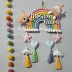 handcrafted macrame rainbow in pastel colors with kids name and cute felt unicorn and felt teddy cotton thread tassles with cute hearts, stars and clouds